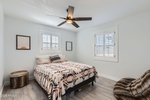 bedroom featuring multiple windows, ceiling fan, and light wood-type flooring