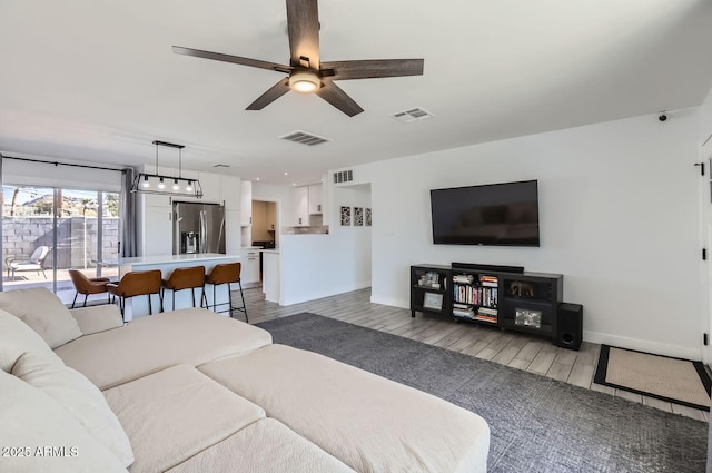 living room with ceiling fan and light hardwood / wood-style flooring