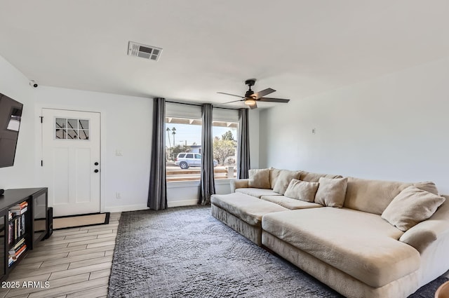 living room featuring wood-type flooring and ceiling fan