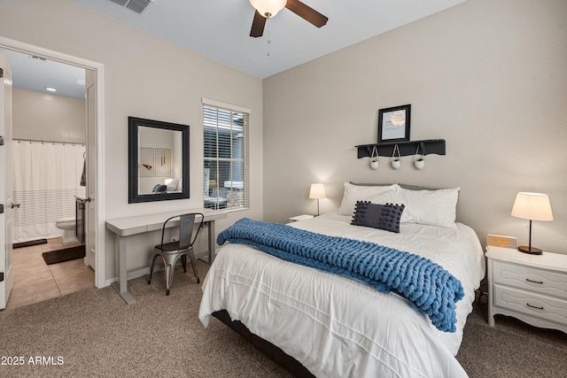 bedroom featuring ceiling fan, carpet floors, baseboards, tile patterned floors, and ensuite bath