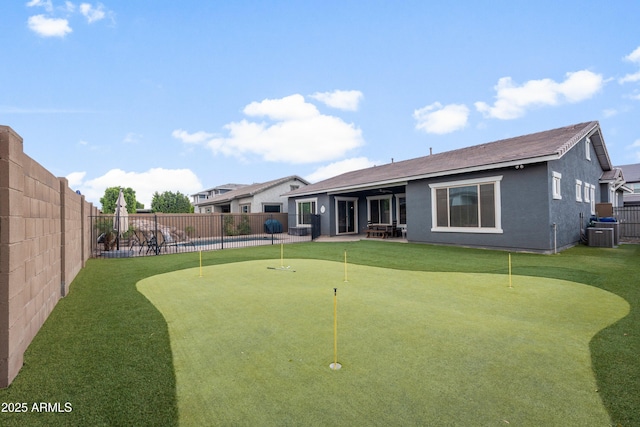 back of property with stucco siding, a patio area, a fenced backyard, and central air condition unit