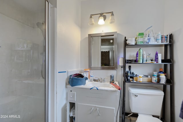 bathroom with vanity, toilet, and a shower with door