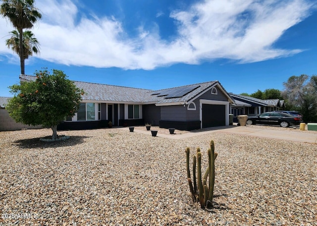 single story home with solar panels and a garage