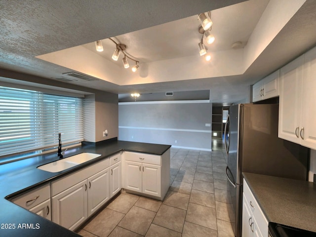 kitchen featuring white cabinets, a raised ceiling, kitchen peninsula, and sink