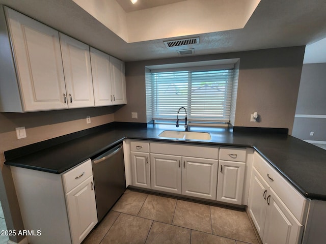 kitchen with white cabinetry, sink, stainless steel dishwasher, kitchen peninsula, and light tile patterned floors