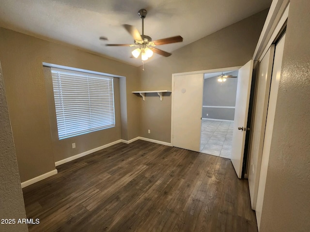 unfurnished bedroom featuring dark hardwood / wood-style floors, ceiling fan, and lofted ceiling