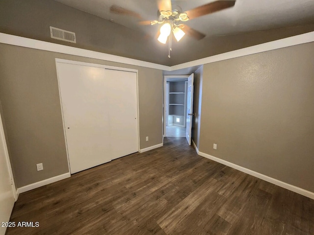 unfurnished bedroom with a closet, vaulted ceiling, ceiling fan, and dark wood-type flooring