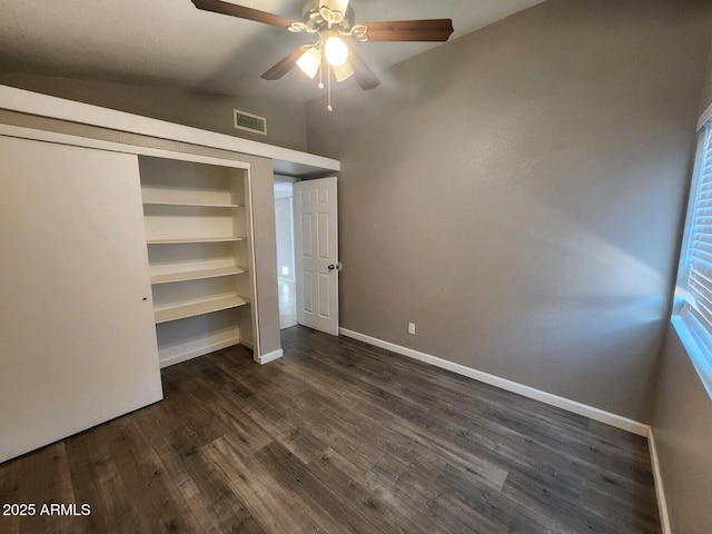 unfurnished bedroom with ceiling fan, a closet, dark wood-type flooring, and vaulted ceiling