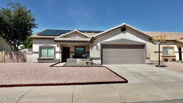 630 E Racine Pl, Casa Grande, AZ 85122 - view of front facade featuring solar panels, a garage, fence, concrete driveway, and stucco siding