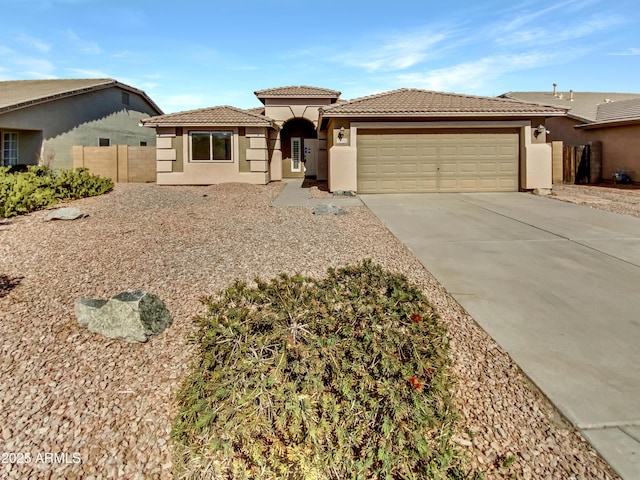 view of front of house featuring concrete driveway, fence, a tile roof, and stucco siding