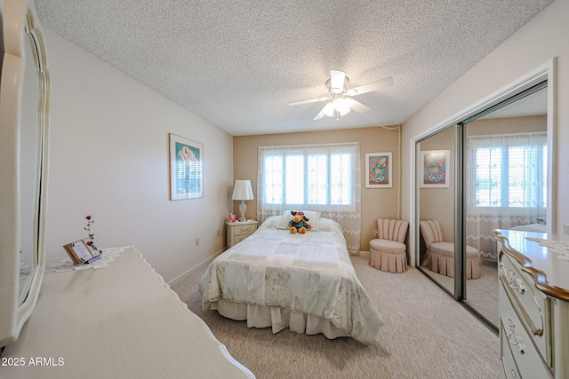 carpeted bedroom featuring a textured ceiling, a closet, and ceiling fan