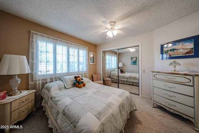 carpeted bedroom with ceiling fan, a closet, and a textured ceiling