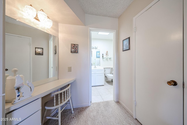 bathroom with vanity, toilet, and a textured ceiling