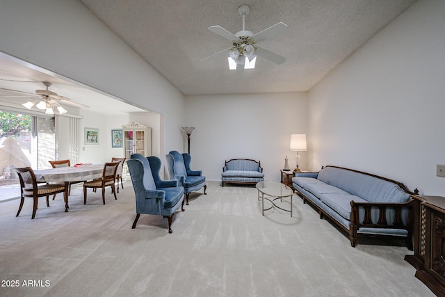 carpeted living room featuring ceiling fan and a textured ceiling