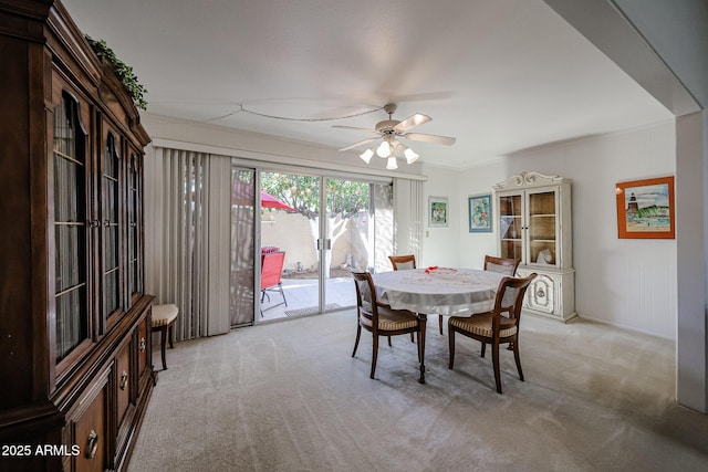 dining space featuring light colored carpet and ceiling fan