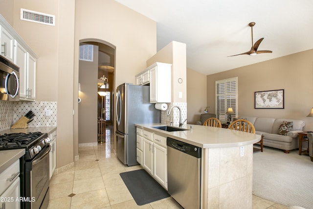 kitchen with tasteful backsplash, sink, stainless steel appliances, and white cabinets