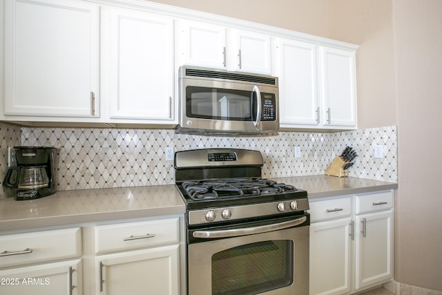 kitchen with white cabinetry, appliances with stainless steel finishes, and tasteful backsplash