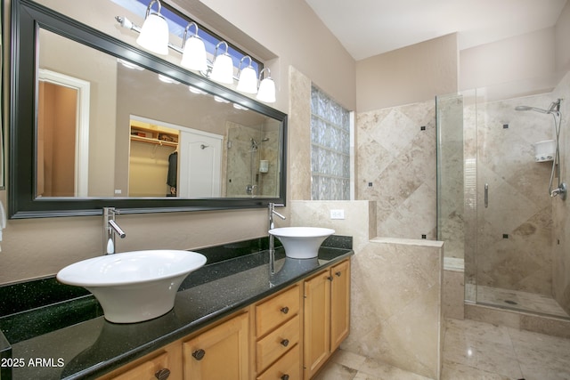 bathroom with tile patterned flooring, vanity, and walk in shower