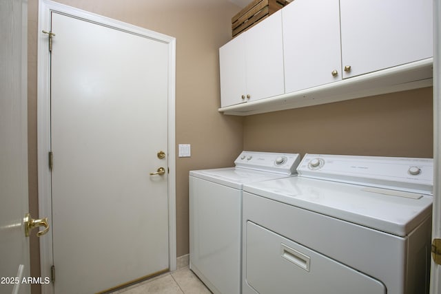 clothes washing area with cabinets, separate washer and dryer, and light tile patterned floors