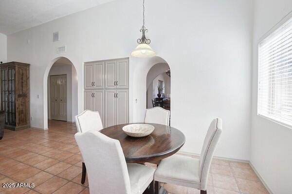 tiled dining space with high vaulted ceiling