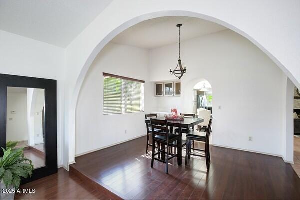 dining room featuring an inviting chandelier, dark hardwood / wood-style floors, and high vaulted ceiling