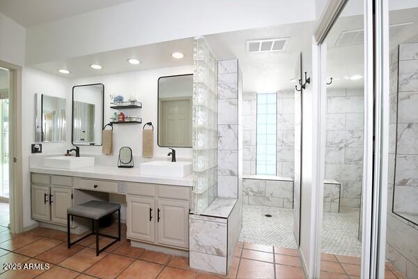 bathroom with vanity, tile patterned flooring, and a tile shower