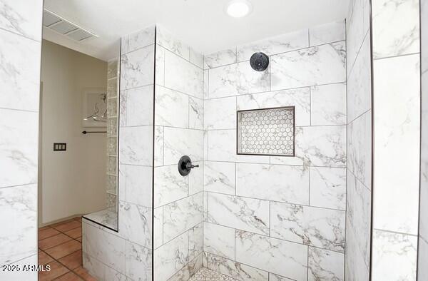 bathroom with tiled shower and tile patterned floors