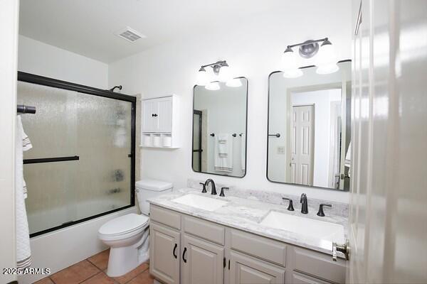 full bathroom featuring toilet, tile patterned floors, shower / bath combination with glass door, and vanity