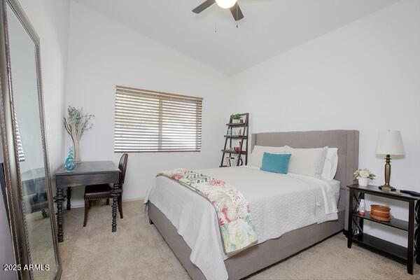 carpeted bedroom featuring lofted ceiling and ceiling fan