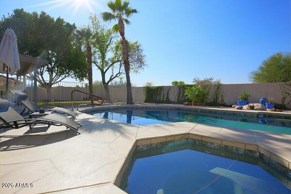 view of pool with a hot tub and a patio