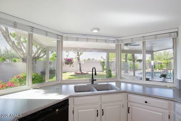 kitchen featuring white cabinetry, dishwasher, and sink