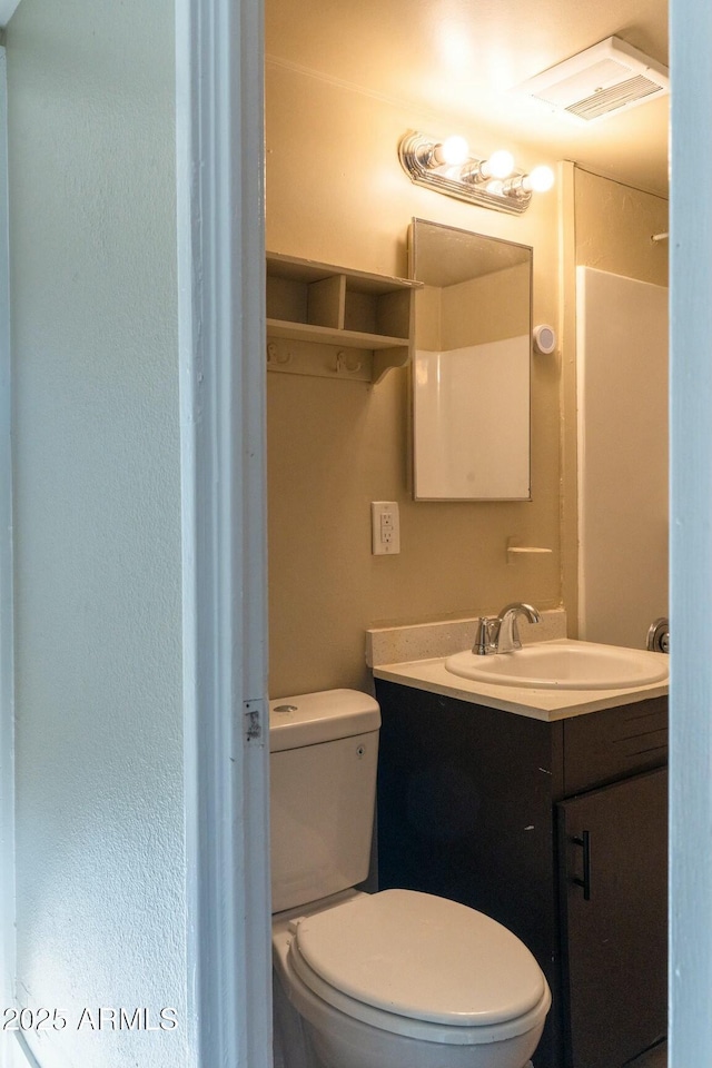 bathroom with visible vents, vanity, and toilet