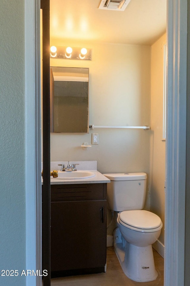 bathroom featuring visible vents, toilet, and vanity