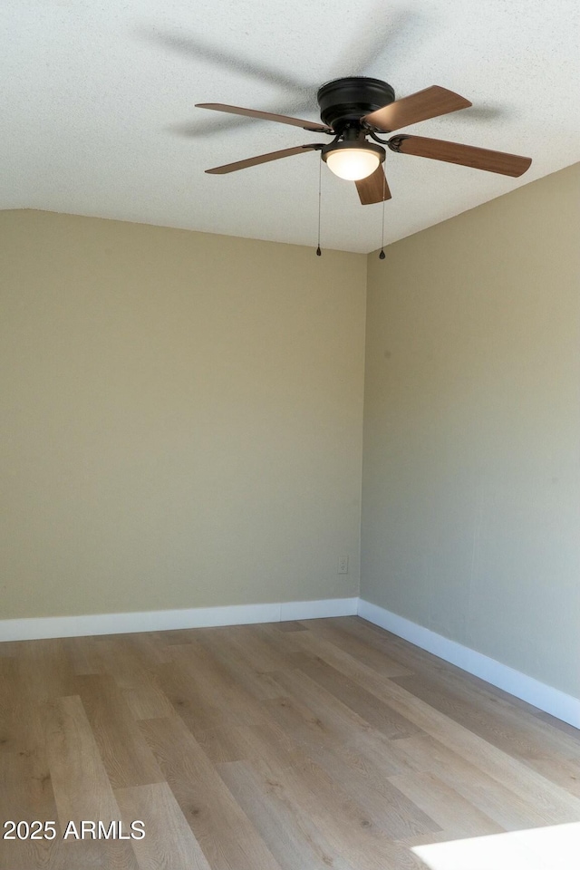 unfurnished room featuring light wood finished floors, baseboards, and a ceiling fan