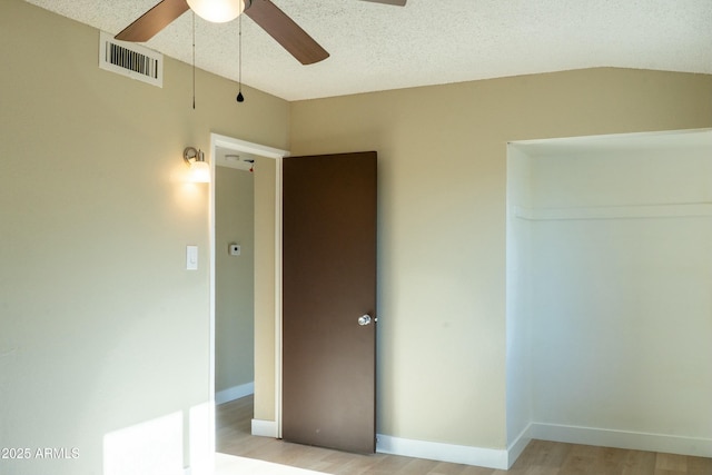 unfurnished bedroom with visible vents, light wood finished floors, baseboards, and ceiling fan