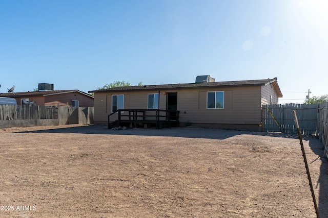 rear view of property with a fenced backyard, central AC unit, and a deck