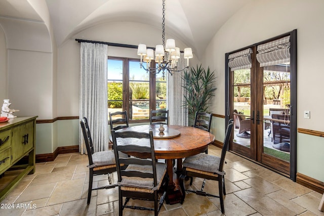 tiled dining area featuring vaulted ceiling and a chandelier