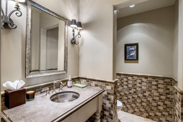 bathroom featuring tile floors, vanity, tile walls, tasteful backsplash, and toilet