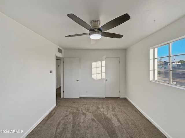 carpeted spare room with ceiling fan