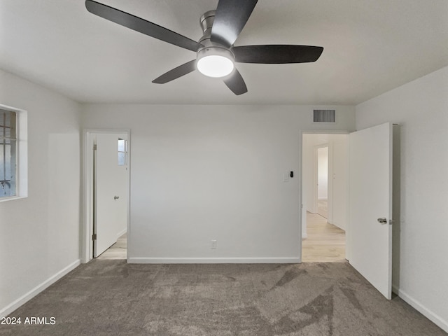 carpeted spare room featuring ceiling fan