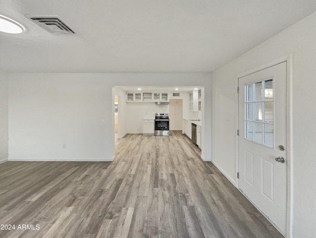 unfurnished living room featuring sink and light wood-type flooring