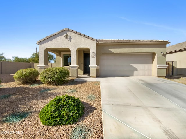 mediterranean / spanish house featuring covered porch and a garage