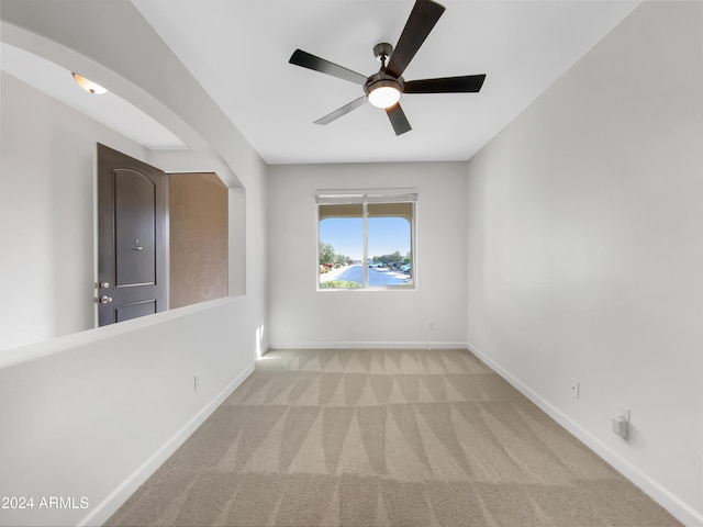 carpeted spare room featuring ceiling fan