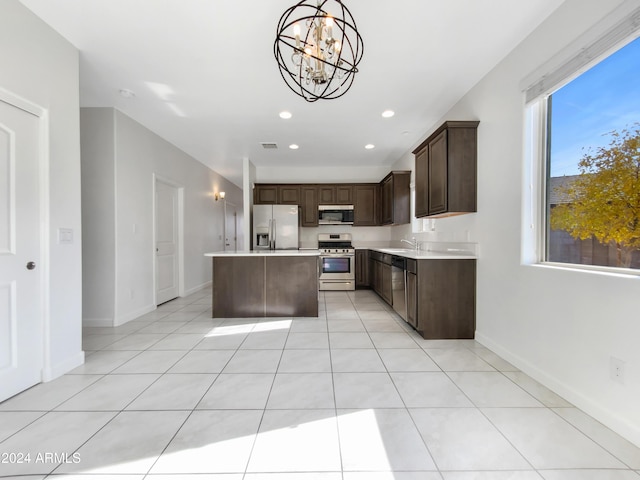 kitchen featuring dark brown cabinetry, hanging light fixtures, stainless steel appliances, a chandelier, and a kitchen island