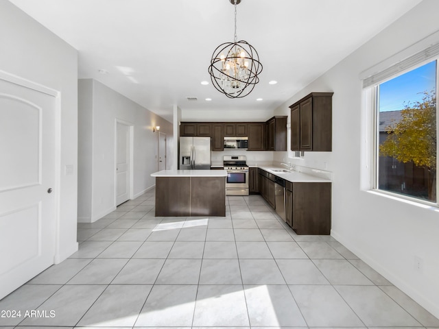 kitchen with pendant lighting, a center island, an inviting chandelier, sink, and stainless steel appliances