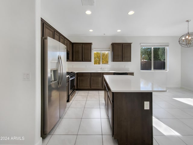 kitchen with hanging light fixtures, a center island, stainless steel appliances, and a wealth of natural light