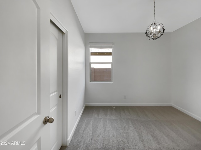 empty room featuring carpet and an inviting chandelier