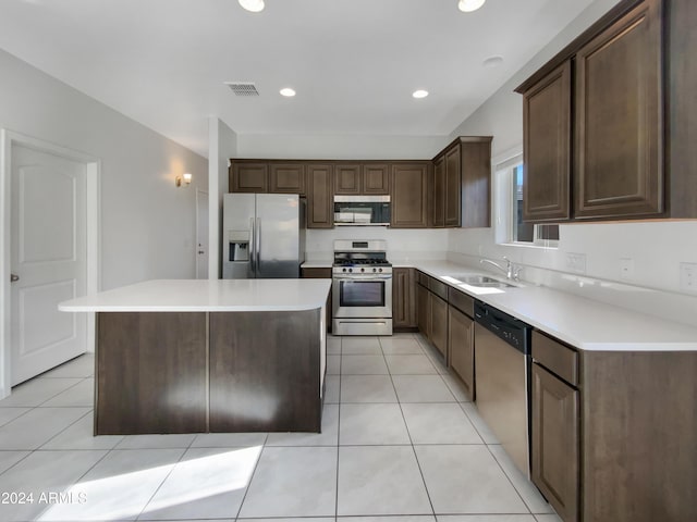 kitchen featuring a center island, sink, dark brown cabinets, light tile patterned flooring, and stainless steel appliances