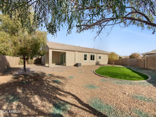 back of property featuring a lawn and central air condition unit