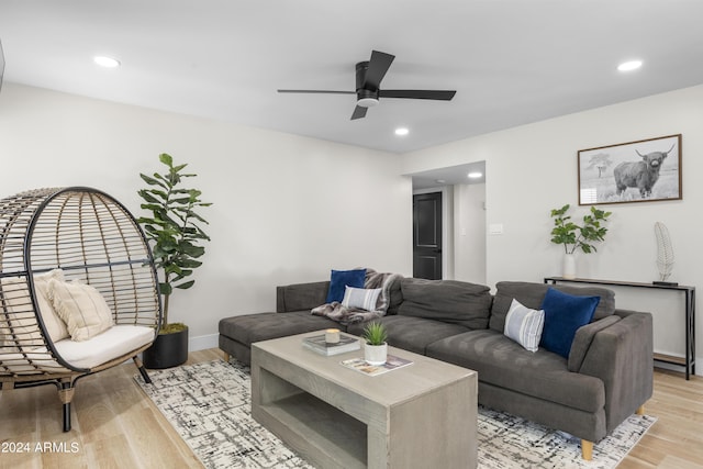 living room with light hardwood / wood-style flooring and ceiling fan